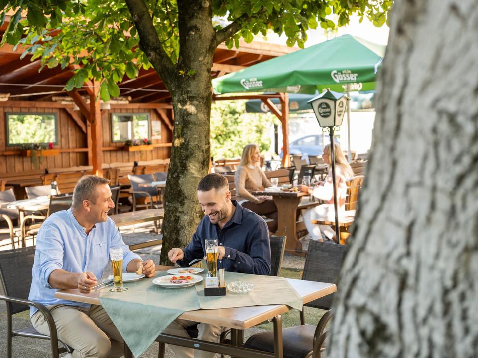 GasthausHuberGastgarten_MännerbeimEssen_TourismusverbandRegionWels.jpg