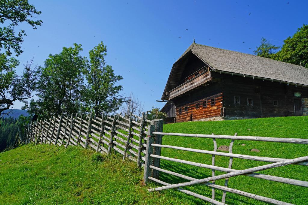 Holzhaus mit Weidezaun und grüner Wiese_Oststeierm