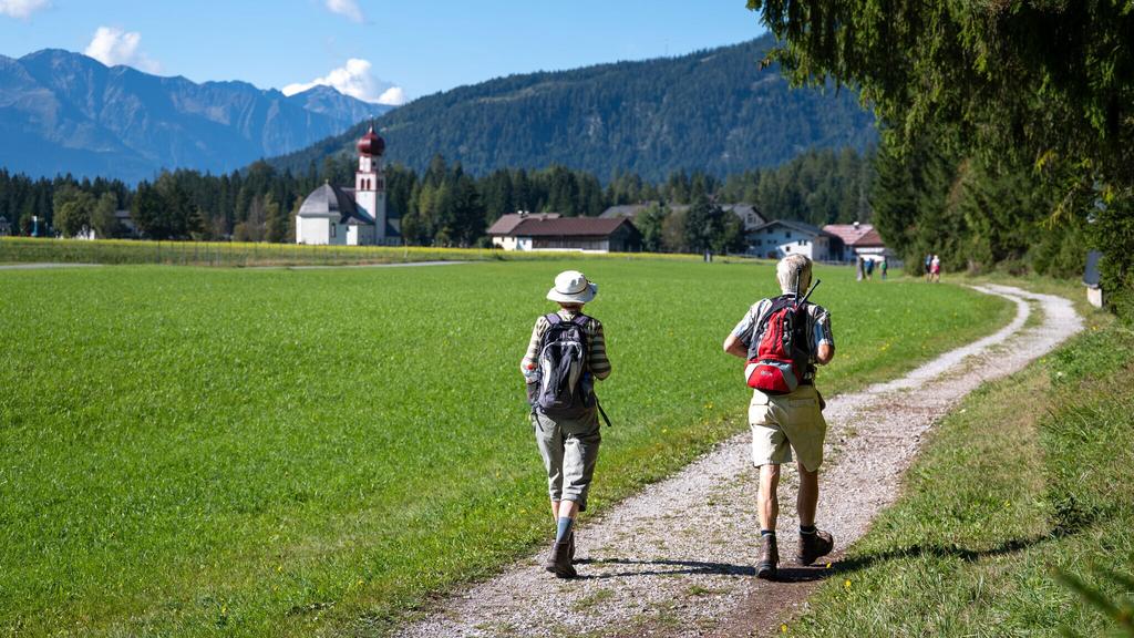 Teilnehmer vom Einhornmarsch auf einem Forstweg auf dem Weg nach Kirchplatzl mit Blick Richtung Kirche.jpg
